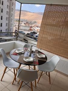 una mesa y sillas en un balcón con vistas en PuestadeSol,Apart en Iquique