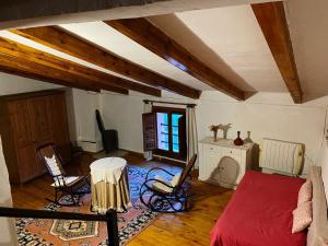 uma sala de estar com uma cama vermelha e cadeiras em El balcón de Reznos, Soria em Soria