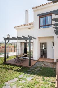 Casa blanca con terraza y mesa en Casa Rural Sierramagna de 1 Dormitorio, en El Ronquillo