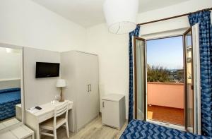 a room with a bed and a desk and a window at Hotel Lucerna in Castiglione della Pescaia +37 photos