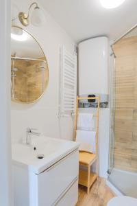 uma casa de banho com um lavatório, um espelho e um chuveiro em Apartament Petunia em Duszniki Zdrój