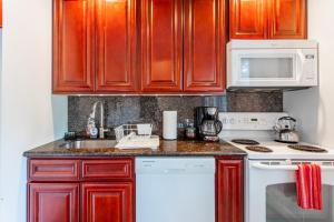 a kitchen with wooden cabinets and a white stove top oven at Redwood Retreat in Windham - minutes to Mtn! in Windham