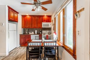 a kitchen with wooden cabinets and a table with chairs at Redwood Retreat in Windham - minutes to Mtn! in Windham