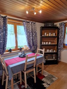 uma sala de jantar com mesa, cadeiras e janelas em FAMILIE BRANDT em Bad Ischl