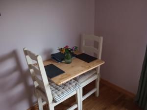 a table and chairs with a vase of flowers on it at Seal Cottage in Portree