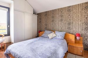 1 dormitorio con 1 cama con edredón azul en La Dolce Vita - T2, en Rennes