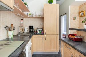 una cocina con armarios de madera y encimeras negras en La Dolce Vita - T2, en Rennes