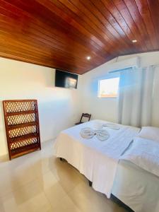 a bedroom with a bed and a wooden ceiling at Piratas do Morro Pousada in Morro de São Paulo
