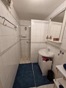 uma casa de banho branca com um lavatório e um chuveiro em FAMILIE BRANDT em Bad Ischl
