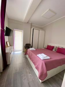 - une chambre avec un grand lit et une couverture rose dans l'établissement Sea View Apartament, à Mamaia Nord – Năvodari