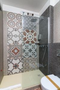 a bathroom with a shower with a toilet and tiles at Elda Hotel in Vico del Gargano