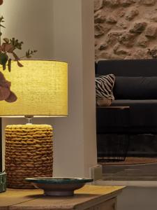 a living room with a yellow lamp on a table at Ático Plaza 9 by casitasconencantoes in Medina Sidonia