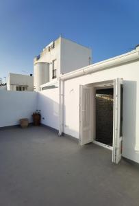 una puerta abierta en el lateral de un edificio blanco en Ático Plaza 9 by casitasconencantoes, en Medina Sidonia