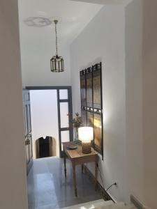 a hallway with a table with a lamp on it at Ático Plaza 9 by casitasconencantoes in Medina Sidonia