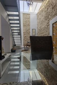 a lobby with a glass floor and a brick wall at Ático Plaza 9 by casitasconencantoes in Medina Sidonia