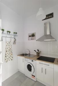 a kitchen with a sink and a washing machine at Ático Plaza 9 by casitasconencantoes in Medina Sidonia