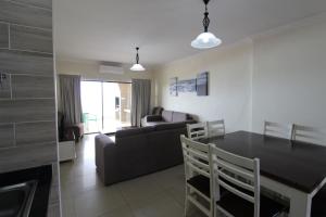 eine Küche und ein Wohnzimmer mit einem Tisch und einem Sofa in der Unterkunft Saints View Resort Unit 23 in Uvongo Beach