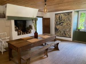 une salle à manger avec une table en bois et une cheminée dans l'établissement Le 44, à Baguer-Pican