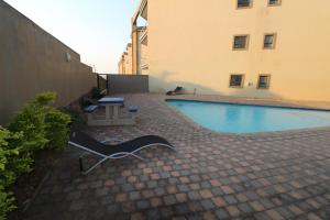 a swimming pool with a chair next to a building at Saints View Resort Unit 23 in Uvongo Beach