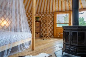 um quarto com uma cama e um fogão a lenha em YURs em Baexem