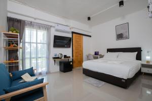 una camera con letto, scrivania e divano di Laewan Guesthouse a Baan Tai