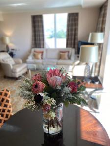a vase of flowers on a table in a living room at Taj Executive Suites, Private Residence in Cape Town