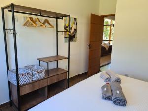 a bedroom with a bed and a closet with shoes at Casa Terracota 2 - Beleza, conforto e sofisticação à 50m do rio in Caravellas