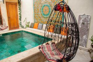 a swing sitting next to a swimming pool at Dar El Halfaouine in Tunis