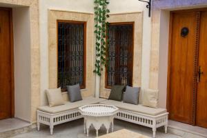 biała ławka siedząca na boku budynku w obiekcie Dar El Halfaouine w mieście Tunis