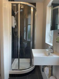 a bathroom with a shower and a sink at Gowanlea Guest House in Balloch