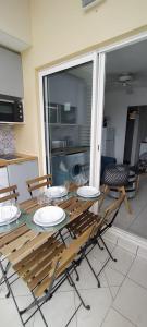 - une table et des chaises en bois dans une chambre avec cuisine dans l'établissement Flamboyant de la Baie, à La Trinité