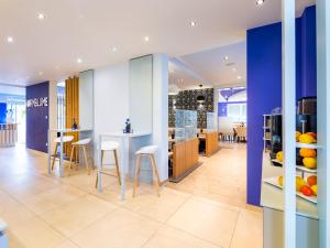 a kitchen and dining room with stools and a counter at Kristallhotel Fettehenne in Leverkusen