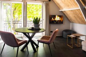 a living room with a table and chairs and a fireplace at Appartement de Hoge Stoep in Hollum
