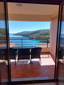 a balcony with a table and chairs and a view of the water at Casa Panorama Studio in Rabac