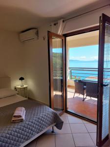 1 dormitorio con cama y vistas al océano en Casa Panorama Studio, en Rabac