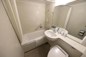 a bathroom with a sink and a toilet and a shower at Smile Hotel Osaka Yotsubashi in Osaka