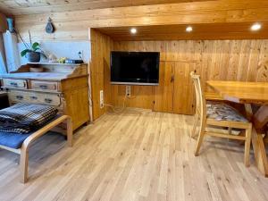 a living room with a dining room table and a tv at Ferienwohnung am Chiemsee in Übersee