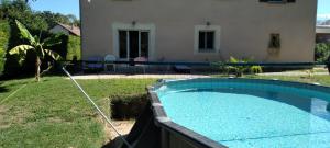 a swimming pool in a yard next to a house at Studio Les Ecureuils in Pont-dʼAin