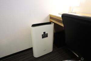 a white trash can sitting next to a desk at Smile Hotel Osaka Yotsubashi in Osaka