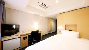 a hotel room with a bed and a desk at Smile Hotel Osaka Yotsubashi in Osaka +16 photos