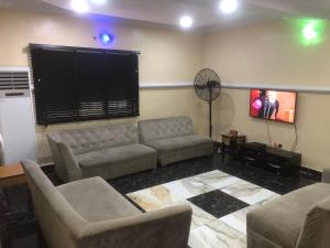 a living room with a couch and a fan at Juicebox B&B in Lagos