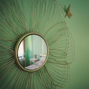 uno specchio con disegno a foglia su una parete di da Rosemarie a Levico Terme