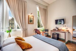 a bedroom with a bed and a desk and window at Tree Charme in Rome