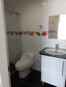 a bathroom with a toilet and a sink at Apartamentos Claudia María in Barbosa