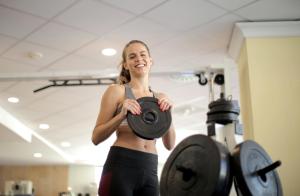 a woman holding a dumbbell in a gym at Kristallhotel Fettehenne in Leverkusen