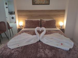 two swans making a heart shape on a bed at Sweet home in Chanioporta in Heraklio Town
