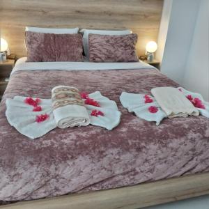 a bed with white towels and red flowers on it at Sweet home in Chanioporta in Heraklio Town