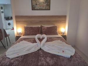 two swans making a heart shape on a bed at Sweet home in Chanioporta in Heraklio Town