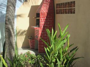 a brick oven in the side of a house with plants at Apartamentos Casa Veneza in Canoa Quebrada