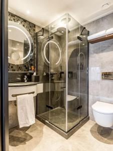 a bathroom with a glass shower and a toilet at Alexander Hotel in Noordwijk aan Zee